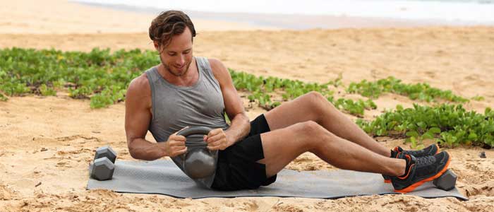 Man performing the Russian Twist exercise outdoors with kettlebell