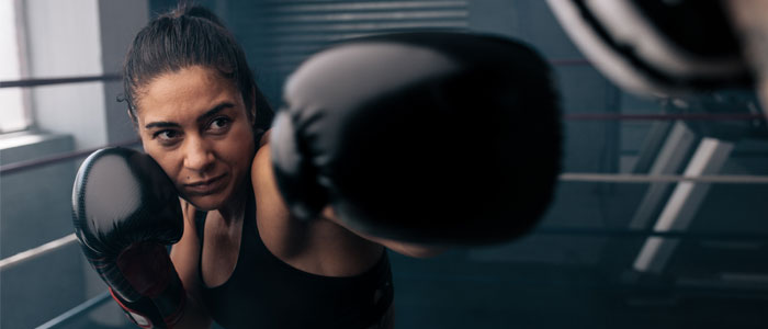 Woman practising boxing punches in a boxing ring