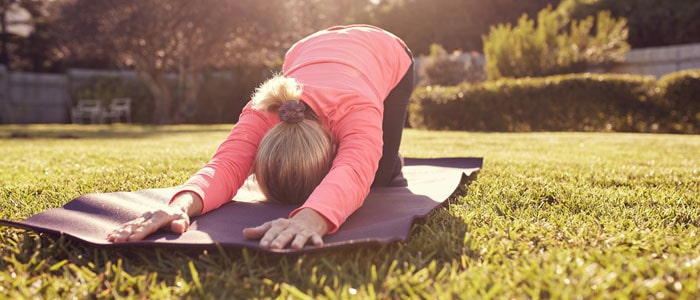 woman engaged in a yoga pose in her garden