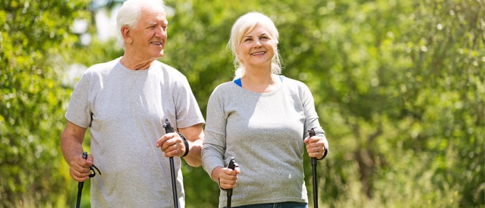 elderly couple nordic walking outdoors