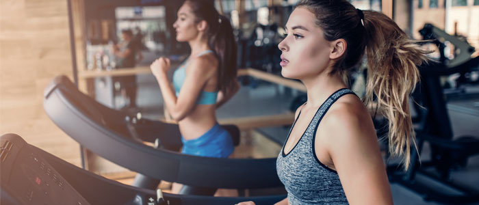 women on treadmills at the gym
